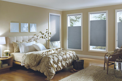 Example of a mid-sized classic guest light wood floor and brown floor bedroom design in DC Metro with beige walls and no fireplace