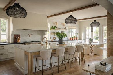 Kitchen - coastal light wood floor and exposed beam kitchen idea in Orange County with open cabinets, marble countertops, stainless steel appliances, an island and white countertops