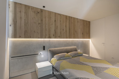 Immagine di una camera matrimoniale minimalista di medie dimensioni con pareti grigie, pavimento in gres porcellanato e pavimento grigio
