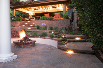 Inspiration for a traditional backyard patio in Los Angeles with a fire feature, concrete pavers and a pergola.