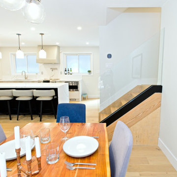 Wood Dining Table Facing the Island and Glass-Railed Stair | North York