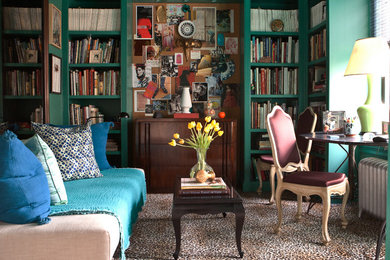 This is an example of a mid-sized transitional enclosed living room in New York with a library, green walls, no fireplace and no tv.