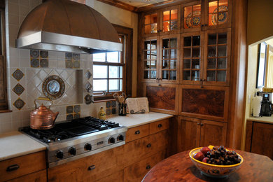 Mid-sized elegant enclosed kitchen photo in Cedar Rapids with flat-panel cabinets, dark wood cabinets, solid surface countertops, multicolored backsplash, ceramic backsplash, stainless steel appliances and no island
