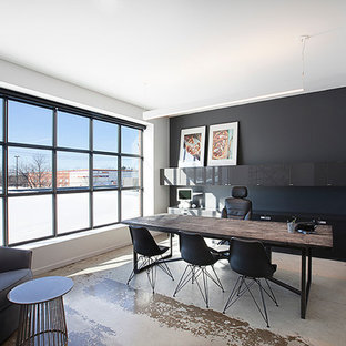 Inspiration for a large modern home office and library in Montreal with black walls, concrete flooring and a freestanding desk.