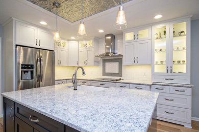 Example of a mid-sized classic u-shaped light wood floor eat-in kitchen design in Grand Rapids with a farmhouse sink, glass-front cabinets, white cabinets, wood countertops, white backsplash, wood backsplash, stainless steel appliances and an island