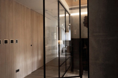 Mid-sized modern hallway with beige walls, light hardwood floors, beige floor and decorative wall panelling.