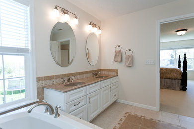 Bathroom - large contemporary master beige tile, brown tile and ceramic tile porcelain tile bathroom idea in Cedar Rapids with raised-panel cabinets, dark wood cabinets, a two-piece toilet, white walls, an undermount sink and granite countertops