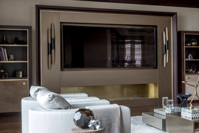 Modelo de salón actual con paredes beige, suelo de madera en tonos medios, televisor colgado en la pared y suelo marrón