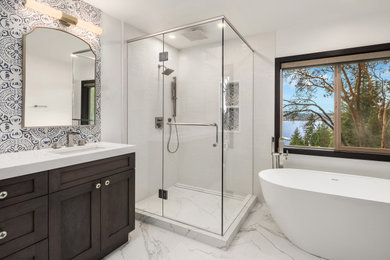 Large beach style master multicolored tile and ceramic tile double-sink bathroom photo in Seattle with shaker cabinets, gray cabinets, a two-piece toilet, white walls, an undermount sink, quartz countertops, a hinged shower door, white countertops and a built-in vanity