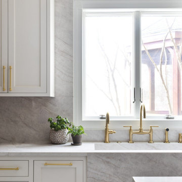 Custom Walnut and White Kitchen Remodel with Marble Slab Backsplash and Brass Ac