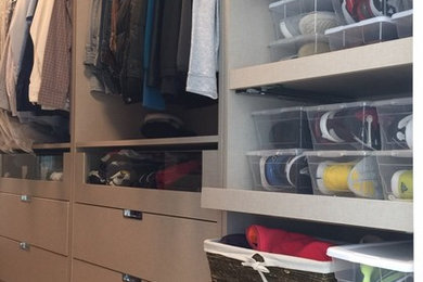 Example of a large minimalist walk-in closet design in Miami with flat-panel cabinets and beige cabinets