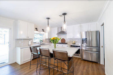 Example of a mid-sized minimalist galley vinyl floor and brown floor eat-in kitchen design in Los Angeles with an undermount sink, quartzite countertops, gray backsplash, quartz backsplash, stainless steel appliances, an island and white countertops