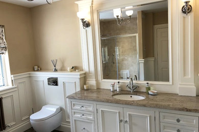 Mid-sized traditional kids bathroom in Other with beaded inset cabinets, beige cabinets, an open shower, a wall-mount toilet, beige tile, marble, beige walls, marble floors, a drop-in sink, granite benchtops, brown floor, a sliding shower screen and beige benchtops.