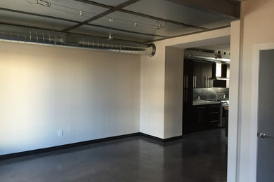 Living room - industrial concrete floor living room idea in Denver with gray walls and no fireplace