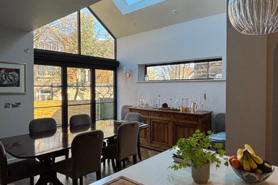 This is an example of a medium sized contemporary kitchen/dining room in Other with medium hardwood flooring, brown floors and a vaulted ceiling.
