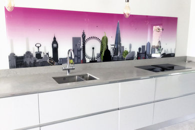 Inspiration for a large modern single-wall open plan kitchen in London with a submerged sink, flat-panel cabinets, white cabinets, concrete worktops, multi-coloured splashback, glass sheet splashback, black appliances, terracotta flooring, no island, grey floors and grey worktops.