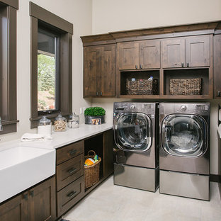 Ejemplo de cuarto de lavado tradicional renovado con fregadero sobremueble, armarios estilo shaker, puertas de armario de madera en tonos medios, paredes beige, lavadora y secadora juntas, suelo beige y encimeras blancas