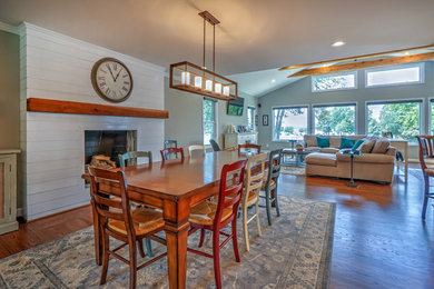 Great room - large transitional medium tone wood floor and brown floor great room idea in Charlotte with gray walls, a standard fireplace and a wood fireplace surround