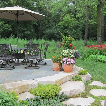 Elevated bluestone patio ringed in limestone outcropping