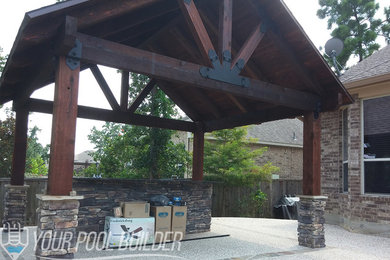 Ejemplo de patio de estilo americano de tamaño medio en patio trasero con cocina exterior, adoquines de piedra natural y cenador