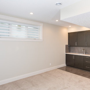 This is an example of a medium sized contemporary fully buried basement in Calgary with beige walls, marble flooring, no fireplace and grey floors.
