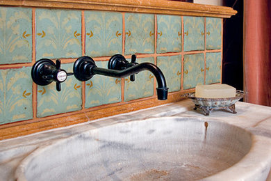 Small tuscan green tile powder room photo in Albuquerque with an integrated sink, furniture-like cabinets, medium tone wood cabinets, marble countertops and beige walls