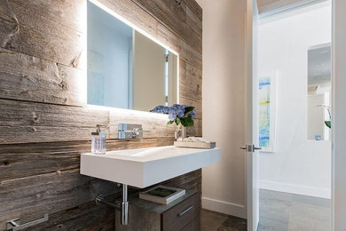 Small minimalist 3/4 gray tile porcelain tile and gray floor bathroom photo in Denver with flat-panel cabinets, dark wood cabinets, a one-piece toilet, brown walls and a wall-mount sink