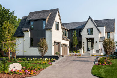 Huge transitional beige two-story brick house exterior idea in Minneapolis with a shingle roof and a gray roof