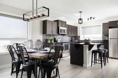 Photo of a mid-sized industrial open plan dining in Calgary with grey walls and light hardwood floors.
