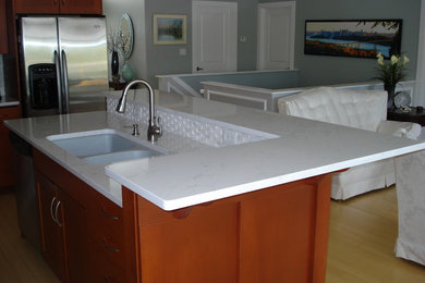 Kitchen - mid-sized contemporary light wood floor kitchen idea in Vancouver with shaker cabinets, medium tone wood cabinets, quartz countertops, white backsplash, ceramic backsplash and stainless steel appliances