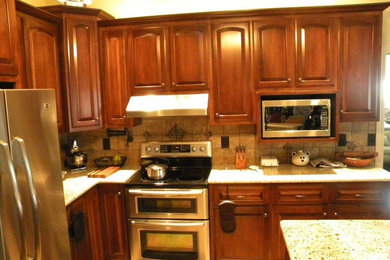 This is an example of a kitchen in Nashville with flat-panel cabinets, medium wood cabinets and with island.