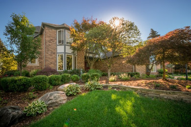 Inspiration for a large timeless beige two-story brick house exterior remodel in Detroit