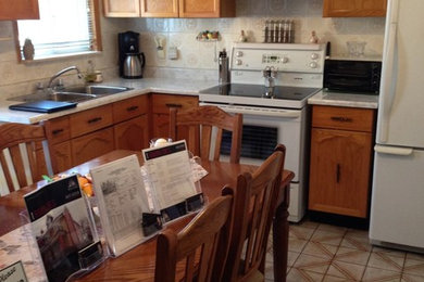 Inspiration for a mid-sized contemporary l-shaped medium tone wood floor open concept kitchen remodel in Toronto with an undermount sink, flat-panel cabinets, white cabinets, quartz countertops, beige backsplash, stone tile backsplash, stainless steel appliances and an island