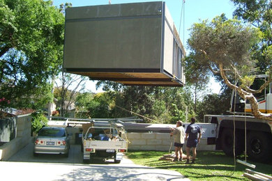 This is an example of a mid-sized modern two-storey grey exterior in Perth with wood siding and a flat roof.