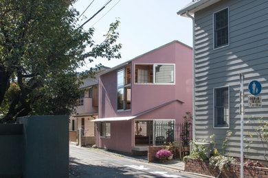 Ejemplo de fachada de casa rosa y gris contemporánea pequeña a niveles con tejado a dos aguas y tejado de metal