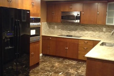 Inspiration for a mid-sized timeless l-shaped porcelain tile and brown floor enclosed kitchen remodel in San Francisco with a double-bowl sink, flat-panel cabinets, dark wood cabinets, granite countertops, multicolored backsplash, matchstick tile backsplash, black appliances and no island