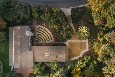 This is an example of a mid-sized contemporary drought-tolerant and partial sun front yard gravel landscaping in Other.