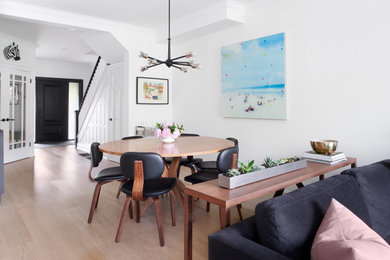 Transitional dining room in Toronto with white walls and light hardwood floors.