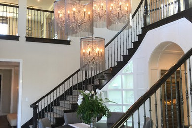 Photo of an expansive traditional wood u-shaped staircase in Orange County with wood risers and metal railing.