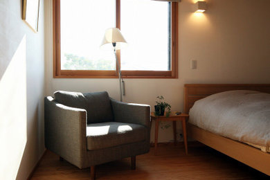 Imagen de dormitorio principal con paredes blancas, suelo de madera en tonos medios y suelo beige