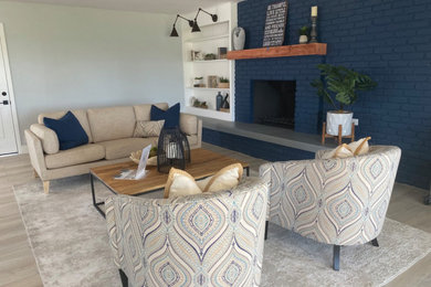Inspiration for a mid-sized coastal enclosed living room remodel in San Diego with blue walls, a brick fireplace and a standard fireplace