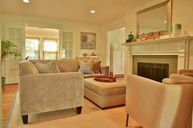 Example of an eclectic light wood floor living room design in Boston with white walls, a standard fireplace and a brick fireplace