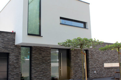 Geräumiges, Zweistöckiges Modernes Einfamilienhaus mit Steinfassade, weißer Fassadenfarbe und Flachdach in Sonstige