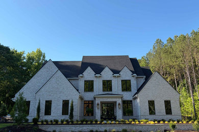 Large transitional gray two-story brick exterior home idea in Atlanta with a shingle roof and a gray roof