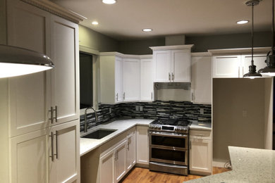 Kitchen - mid-sized kitchen idea in Vancouver with shaker cabinets, white cabinets, granite countertops and an island