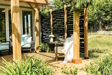 Example of a mid-sized mountain style backyard patio design in Toronto with decking and a pergola