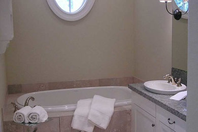 Mid-sized arts and crafts 3/4 beige tile and ceramic tile ceramic tile drop-in bathtub photo in Portland with a drop-in sink, flat-panel cabinets, white cabinets, laminate countertops and white walls