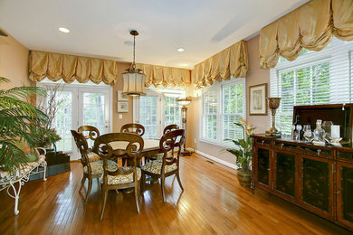 Example of a mid-sized trendy medium tone wood floor dining room design in Baltimore
