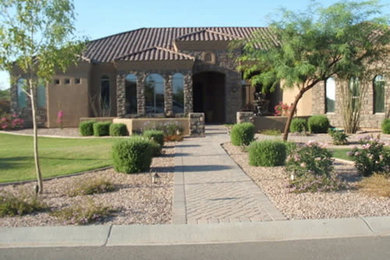 Photo of a mid-sized traditional partial sun front yard stone landscaping in Phoenix.