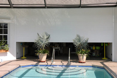 Mid-sized elegant backyard concrete paver and rectangular lap pool photo in Miami